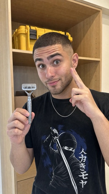 Man holding an Oxley razor beside his face